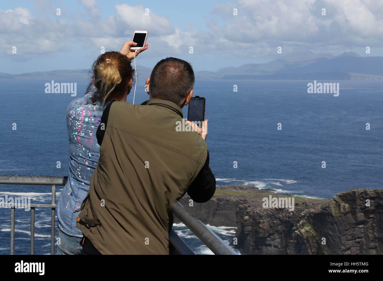 Sur le couple Fogher falaises, Valentia Island, comté de Kerry, Irlande prendre des photographies sur téléphone mobile. Banque D'Images