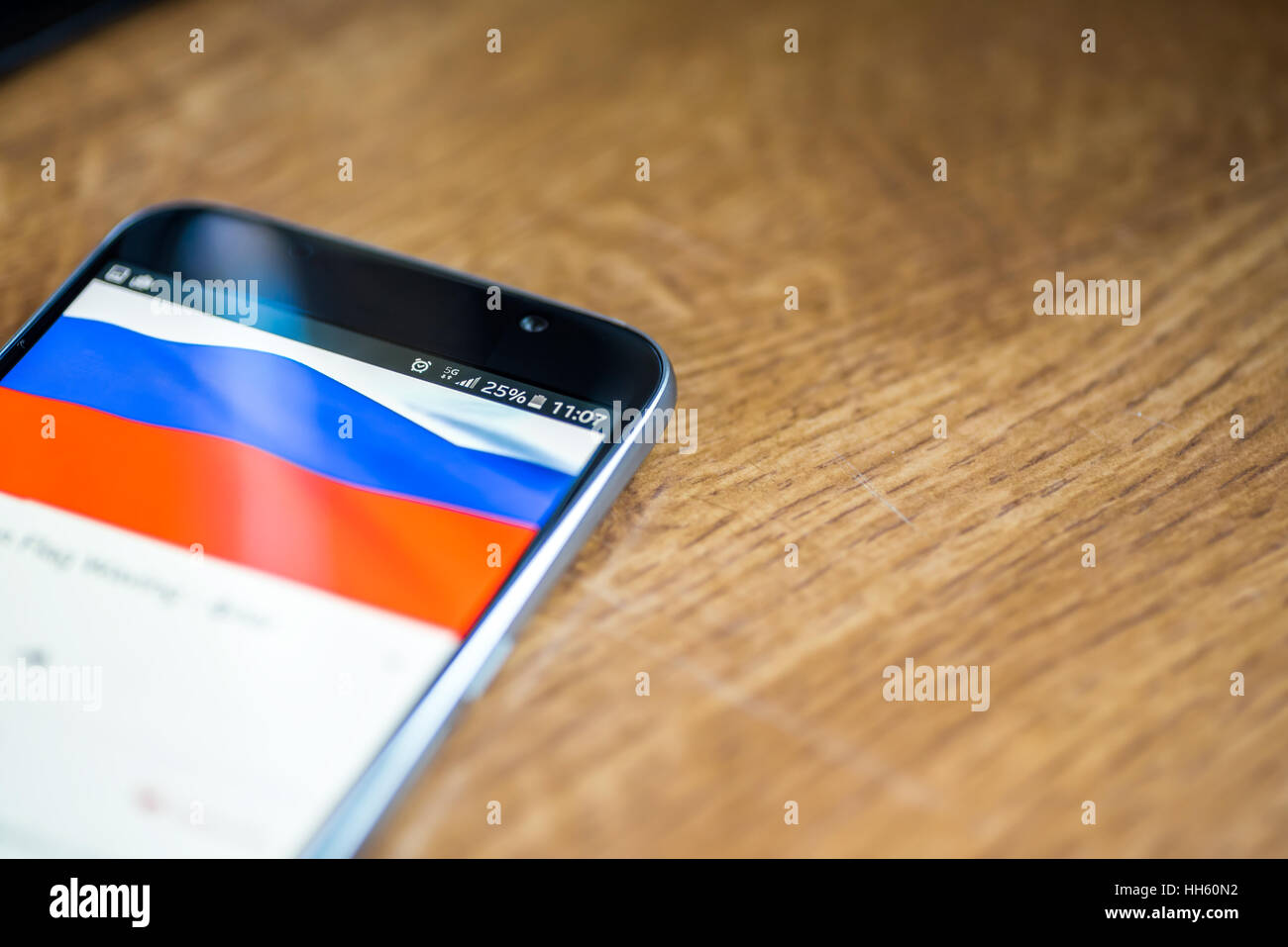 Sur fond de bois avec smartphone 5G Réseau inscription 25  % et la Russie drapeau sur l'écran. Banque D'Images