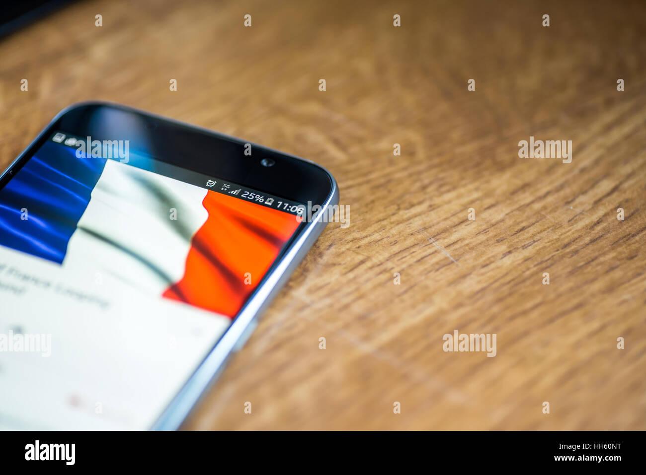 Sur fond de bois avec smartphone 5G Réseau inscription 25  % et la France drapeau sur l'écran. Banque D'Images