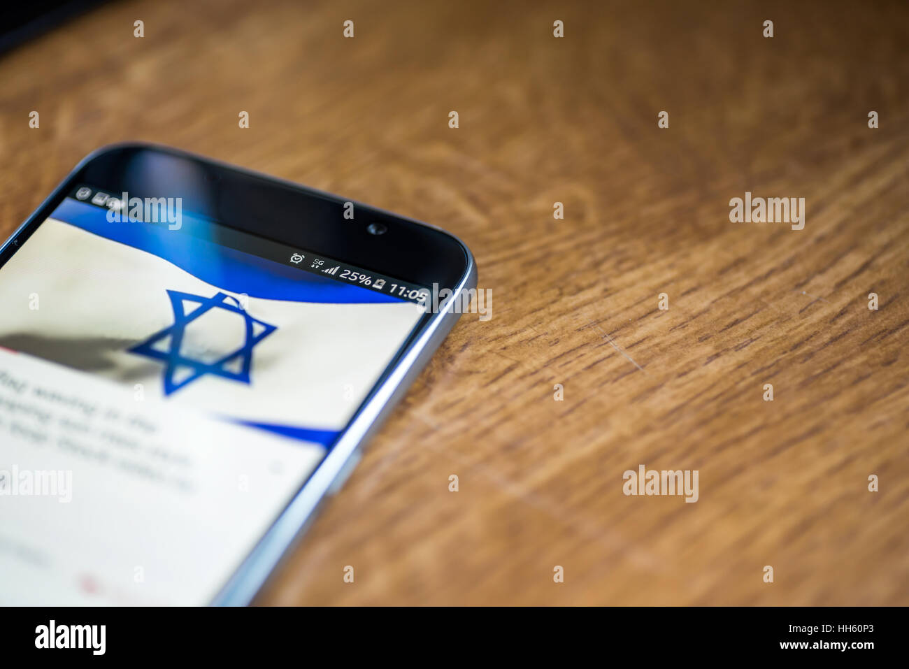 Sur fond de bois avec smartphone 5G Réseau inscription 25  % et Israël drapeau sur l'écran. Banque D'Images
