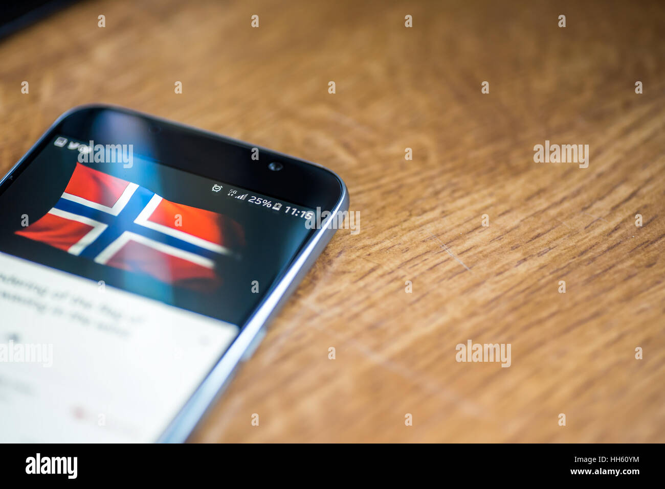 Sur fond de bois avec smartphone 5G Réseau inscription 25  % et la Norvège drapeau sur l'écran. Banque D'Images