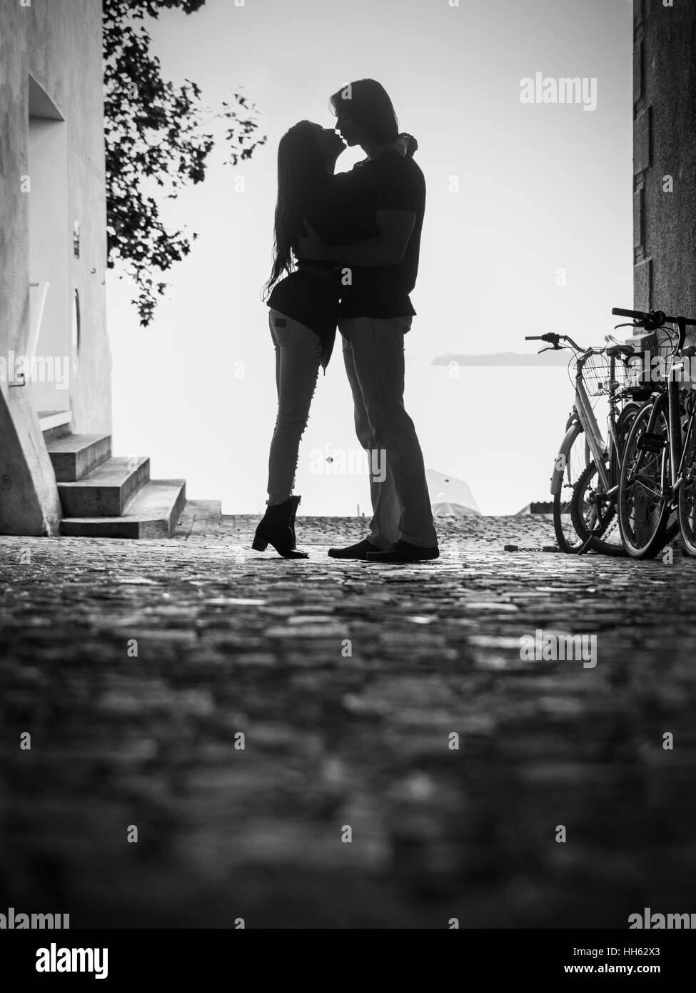 Photo d'une jeune femme et l'homme embrassant et embrasser dans une ruelle. Grain légèrement visible. Banque D'Images