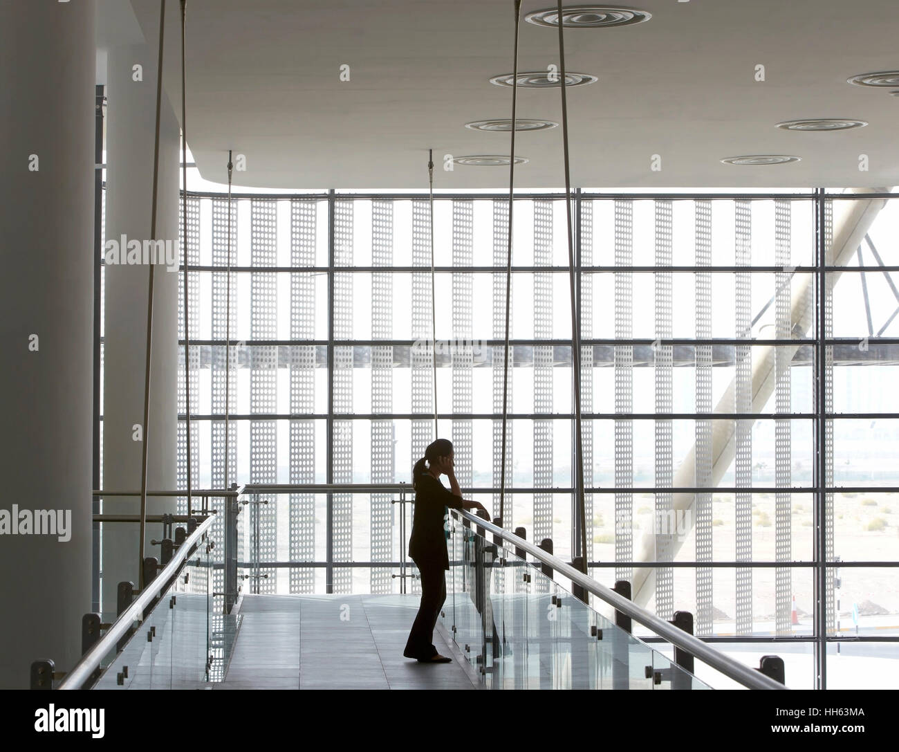 Couloir Mezzanine avec silhouetté figure. Masdar Siemens, Abu Dhabi, Emirats Arabes Unis. Architecte : Sheppard Robson, 2014. Banque D'Images