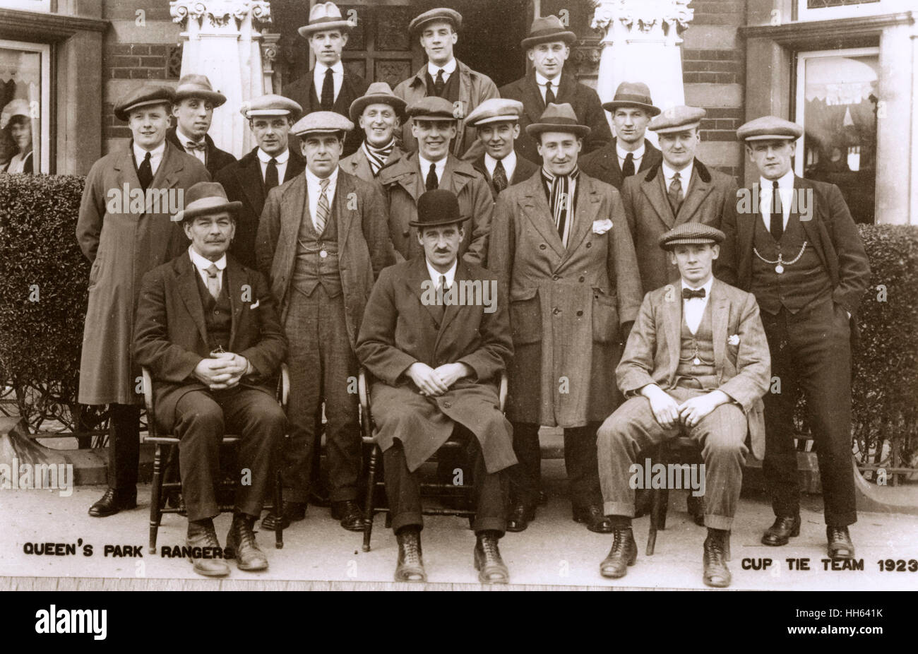 Queens Park Rangers FC L'équipe de football et de la gestion, de l'équipe de coupe 1923, posant en costumes et manteaux à l'extérieur d'une maison. Banque D'Images