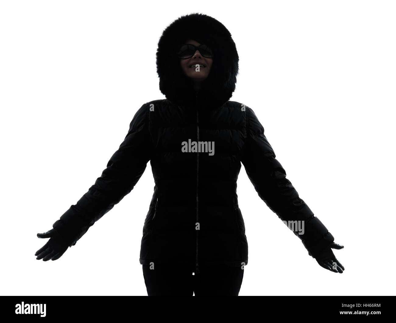 Une femme en manteau d'hiver les bras tendus heureux silhouette sur fond blanc Banque D'Images