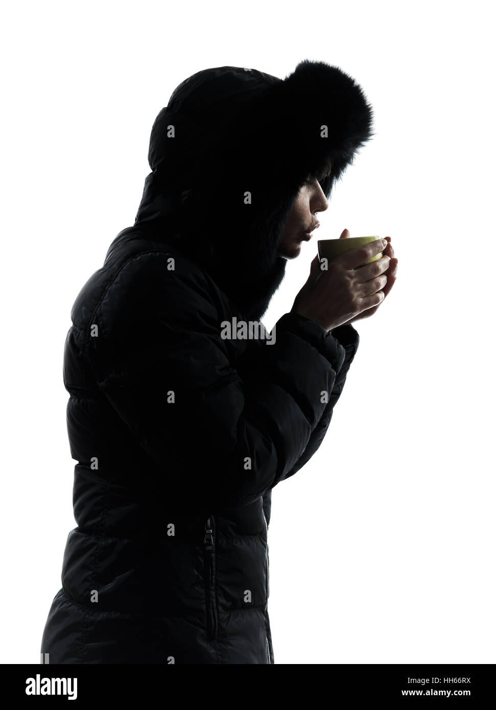 Une femme en manteau d'hiver de boire une boisson chaude silhouette sur fond blanc Banque D'Images