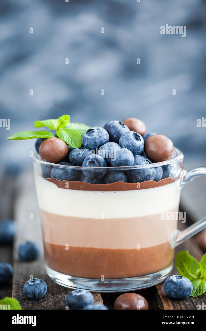 Trois délicieux dessert mousse au chocolat en couches, devorated avec de bleuets frais, de menthe et de bonbons, servi dans la tasse en verre Banque D'Images