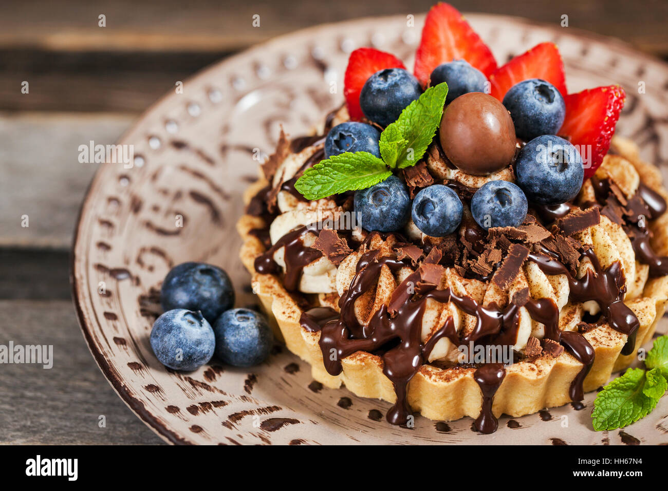 Banoffee pie (tart) décorées avec du chocolat, de fraises et de bleuets frais Banque D'Images