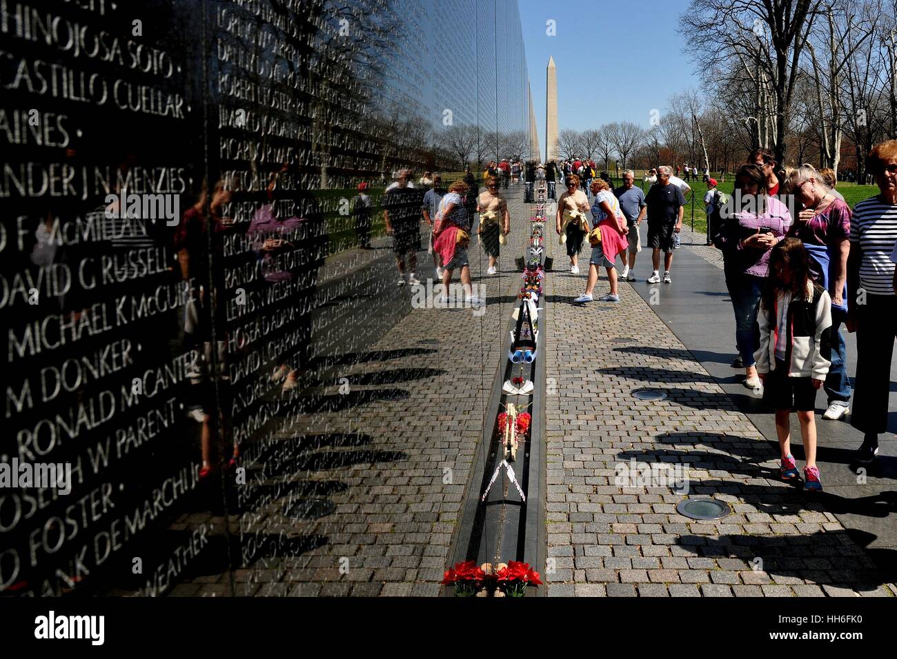 Washington, DC - 10 Avril 2014 : Visiteurs visualisation du mur de granit noir avec inscrit le nom d'un militaire tombé au Vietnam War Memorial Banque D'Images