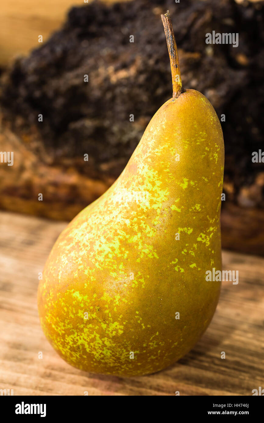 Goût sucré et une poire mûre (Pyrus communis) sur planche à découper en bois. Pear est de la variété Conférence, souvent utilisé comme dessert ou en cooki Banque D'Images