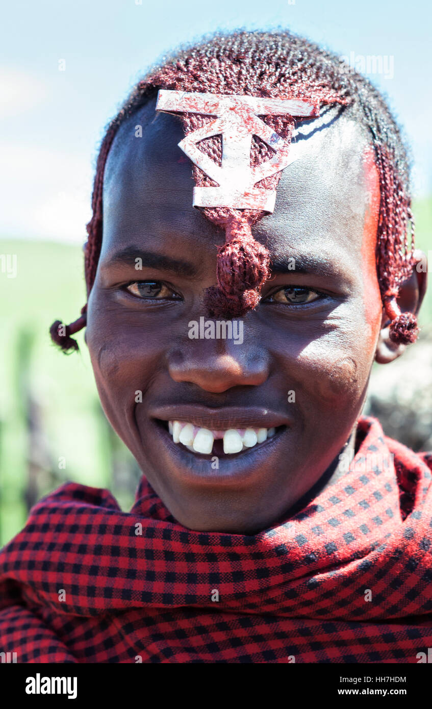 Portrait d'un jeune guerrier Maasai africain dans la zone de conservation de Ngorongoro près du cratère de Ngorongoro, Tanzanie, Afrique de l'est. Tous les jours reportage de la vie dans le village de Maasai. Banque D'Images