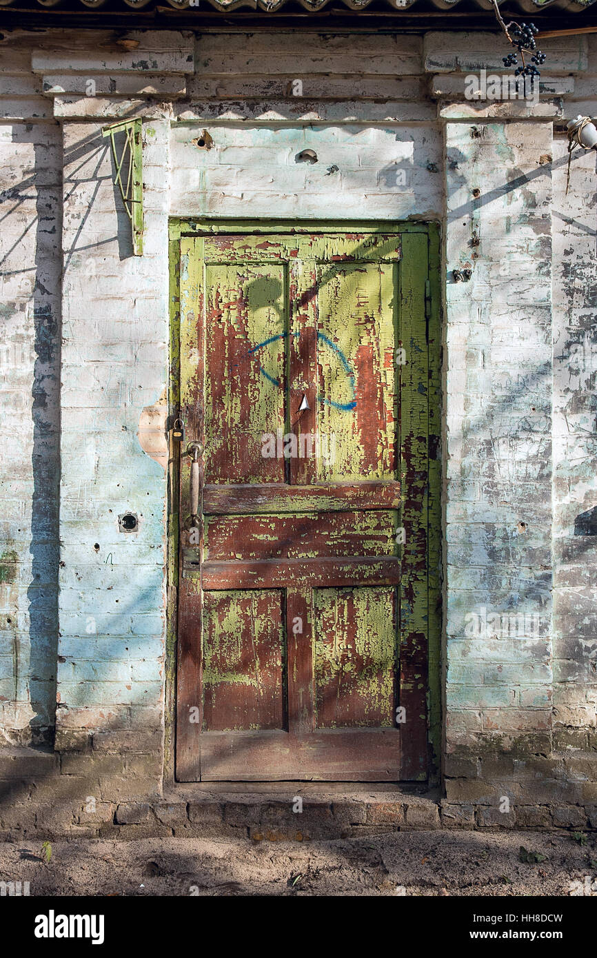 Vue rapprochée de la vieille porte en bois avec peinture la couleur est arrachée. Peinture écaillée sur porte de maison abandonnée comme texture de fond bois vintage. Banque D'Images