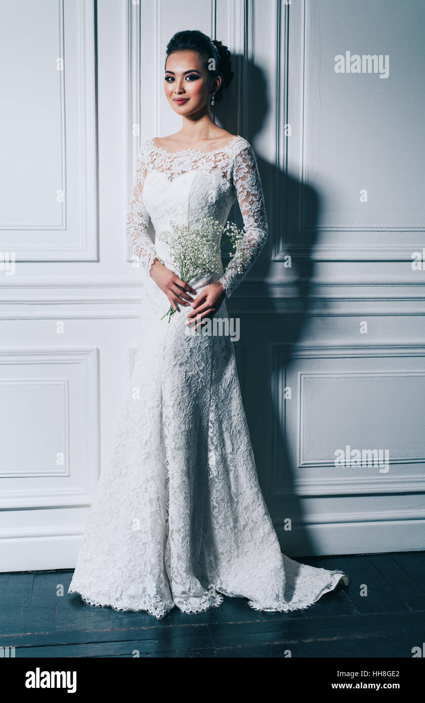 Jeune femme en robe blanche avec des fleurs fashion portrait Banque D'Images