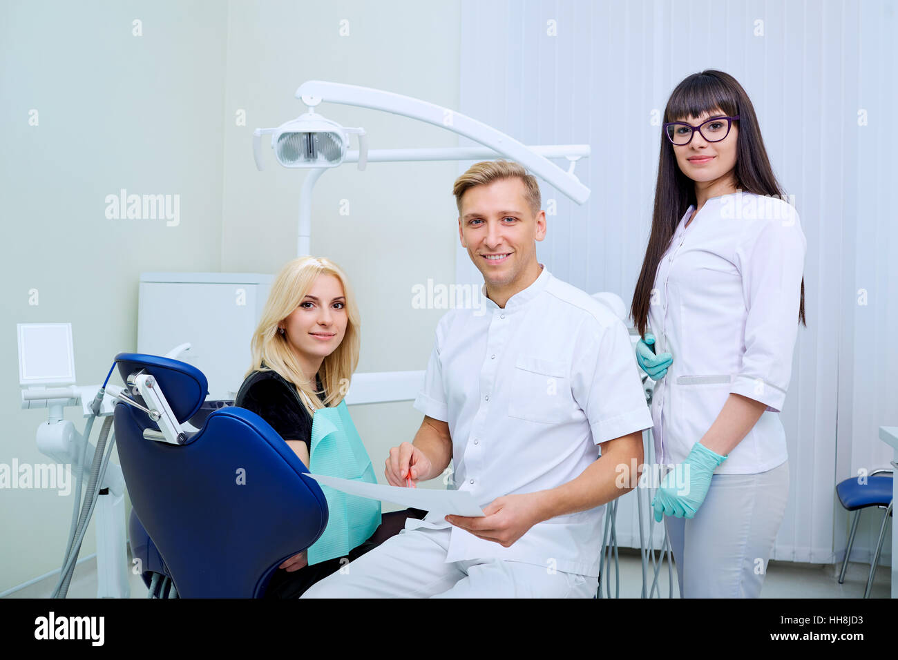 Le patient, le dentiste et l'assistant de bureau de la clinique dentaire Banque D'Images