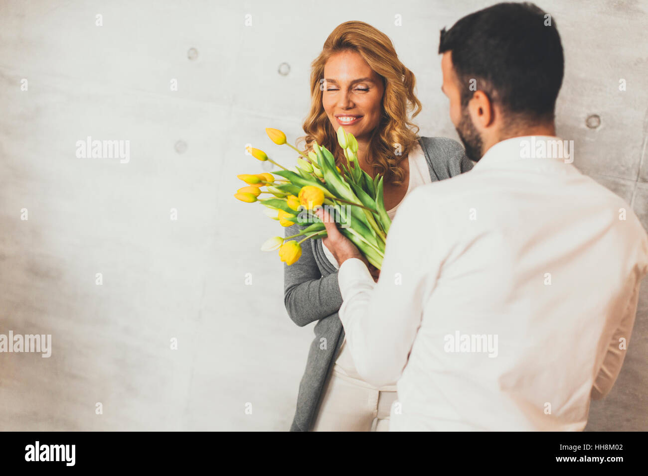 Jeune homme donnant à la fille un bouquet de tulipes Banque D'Images