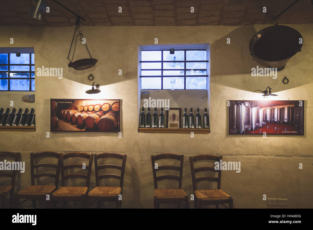 L'intérieur de la Corte d'Aibo bar en Italie avec des bouteilles de vin exposés sur les murs et les chaises vides alignés près du mur Banque D'Images