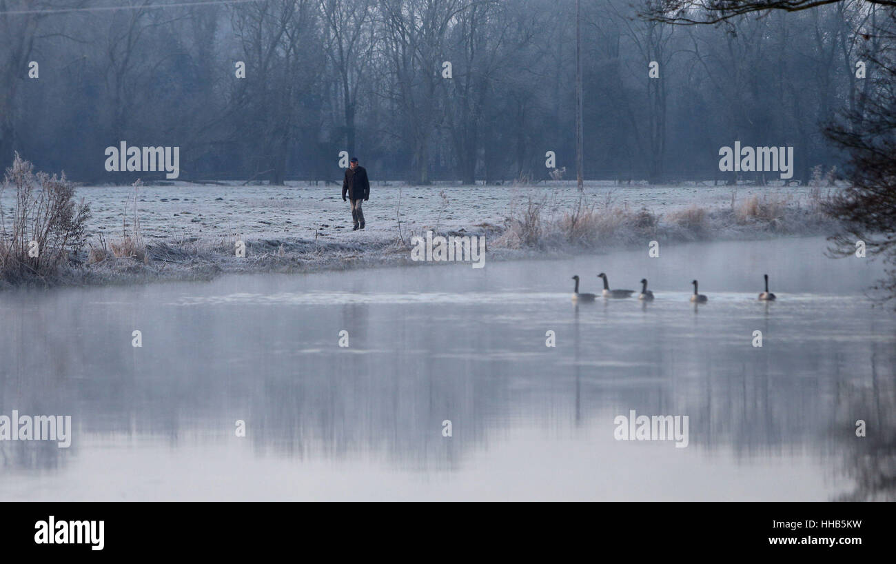 Un marcheur marche sur un chemin de halage givré à côté du Kennet and Avon Canal près de Sulhamstead dans Berkshire après la nuit dans le sud-est de l'Angleterre a chuté au-dessous de zéro. Banque D'Images