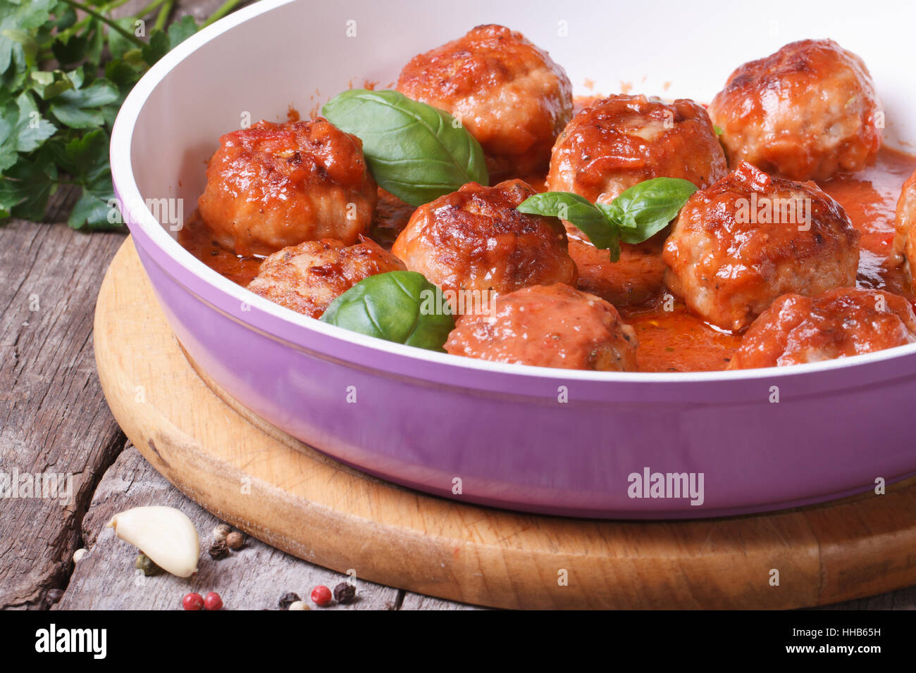 Petites boulettes de viande fraîche avec une sauce tomate dans une poêle sur une table en bois Banque D'Images