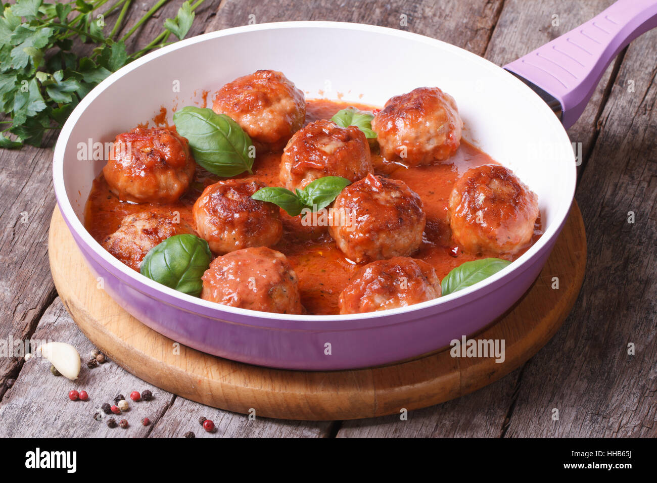 Petites boulettes de viande avec sauce tomate dans une poêle sur une table en bois Banque D'Images