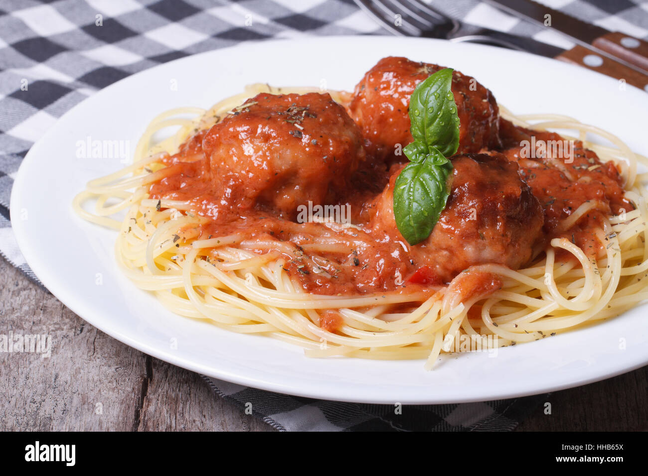 Petites boulettes de viande avec une sauce tomate et des pâtes sur une plaque blanche sur la table Banque D'Images