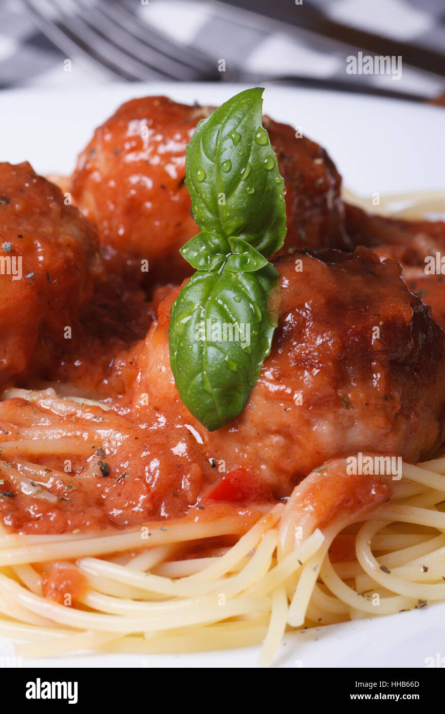 Spaghetti aux boulettes de pâtes et sauce tomate sur une plaque blanche sur la table verticale. Banque D'Images