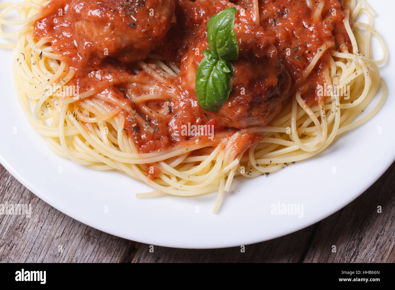 Spaghetti aux boulettes de pâtes et sauce tomate sur une plaque blanche sur un dessus de table view. Banque D'Images