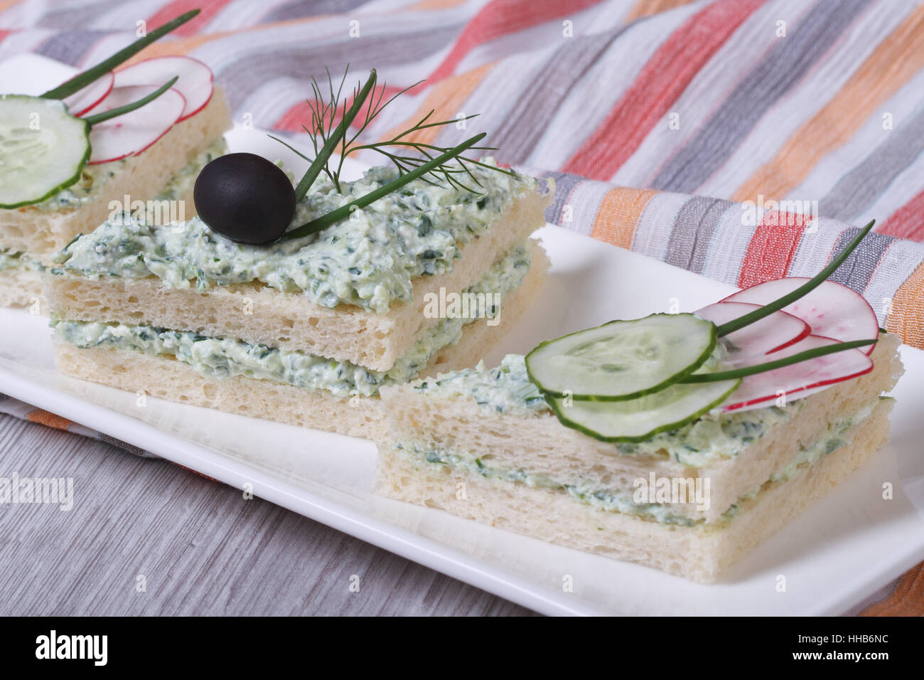 Sandwiches double couche avec fromage, concombres, radis et les olives sur le gros plan de la plaque Banque D'Images