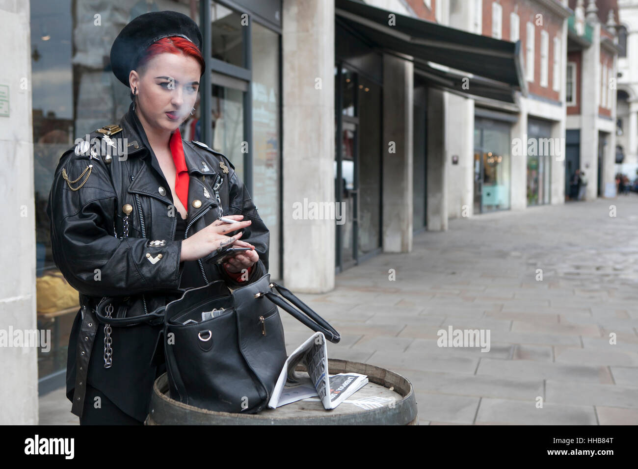 Londres, Royaume-Uni - 27 août 2016 : Girl with red hair habillés dans un style militariste de fume dans la rue. Banque D'Images