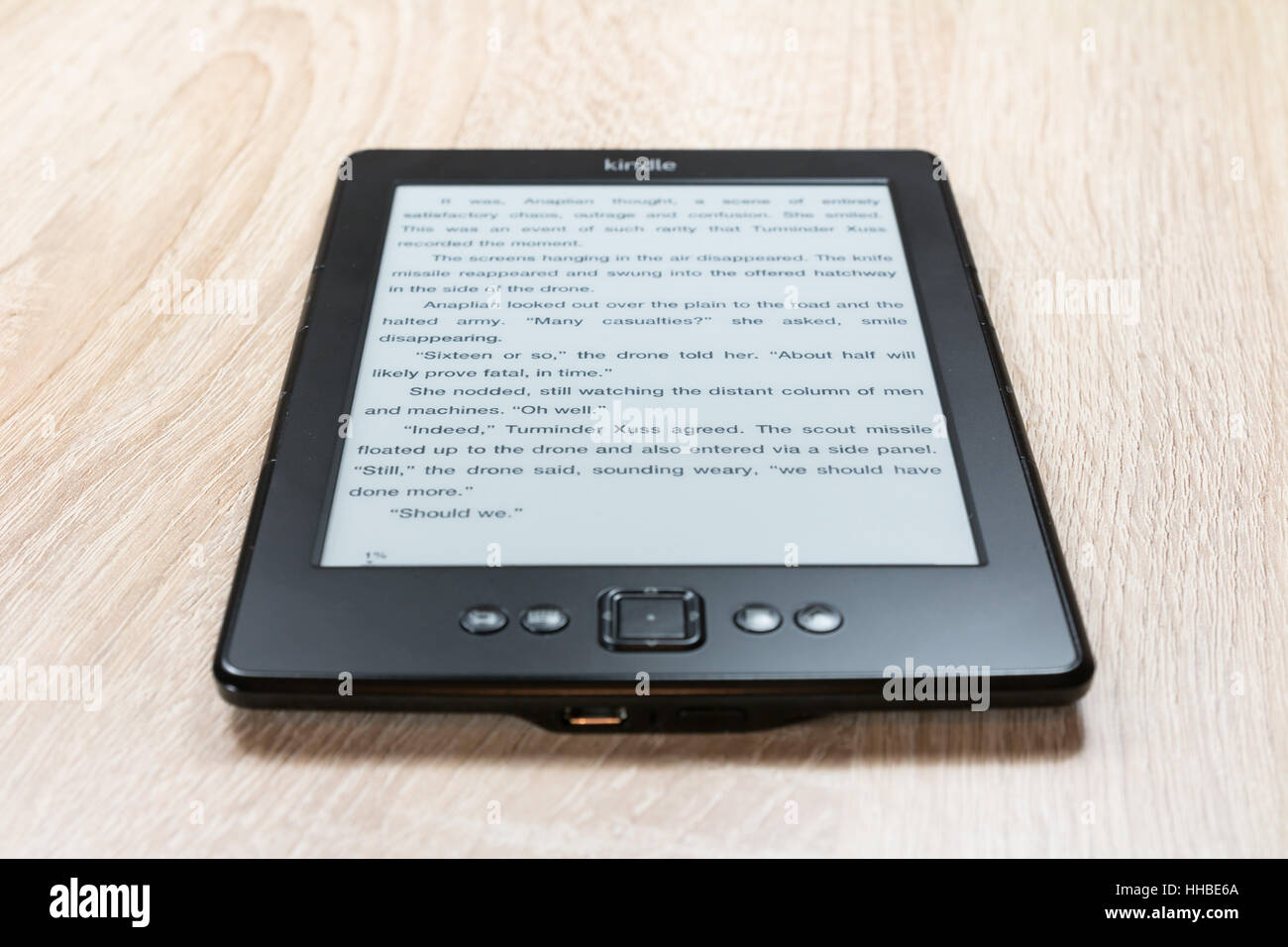Kindle Ebook Reader avec affiche la page d'un livre sur la table. Banque D'Images
