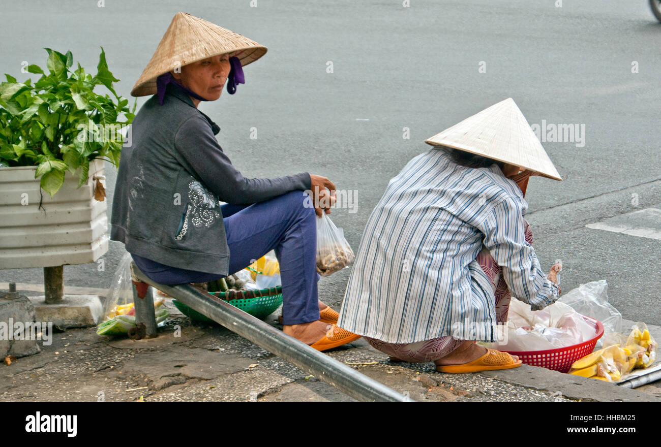 Deux femmes les vendeurs de rue, assis dans la rue la vente de bananes. Banque D'Images