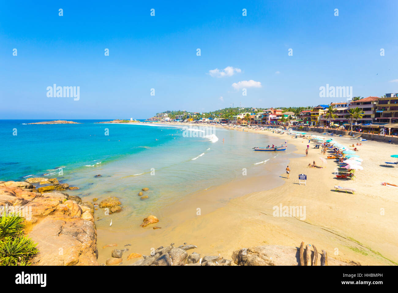 Ligne hôtels une passerelle au-dessus du sable en face d'un océan bleu coloré à Kovalem Light House Beach au Kerala Banque D'Images