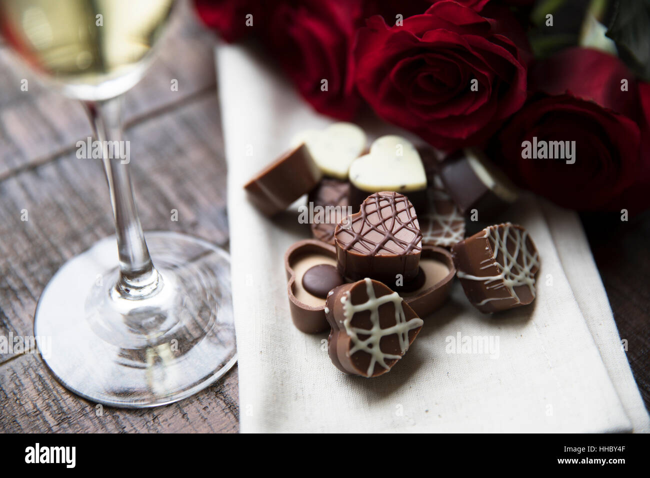 Chocolats en forme de coeur romantique avec des roses rouges et champagne. Banque D'Images