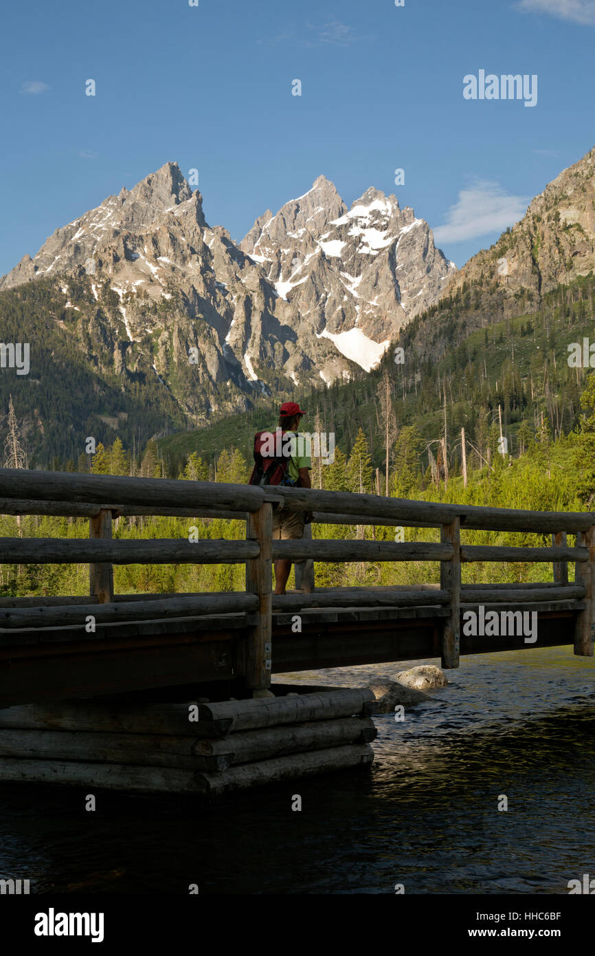 WYOMING - Hiker traversant le lac de chaîne sur le pont d'actions au début du canyon Cascade randonnée dans le Grand Teton National Park. Banque D'Images