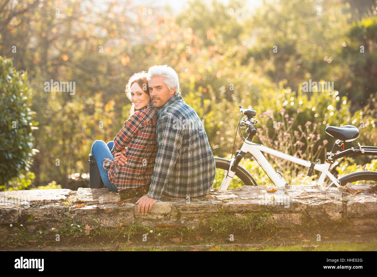 Affectueux Portrait couple avec location reposant sur mur de pierre dans la région de autumn park Banque D'Images