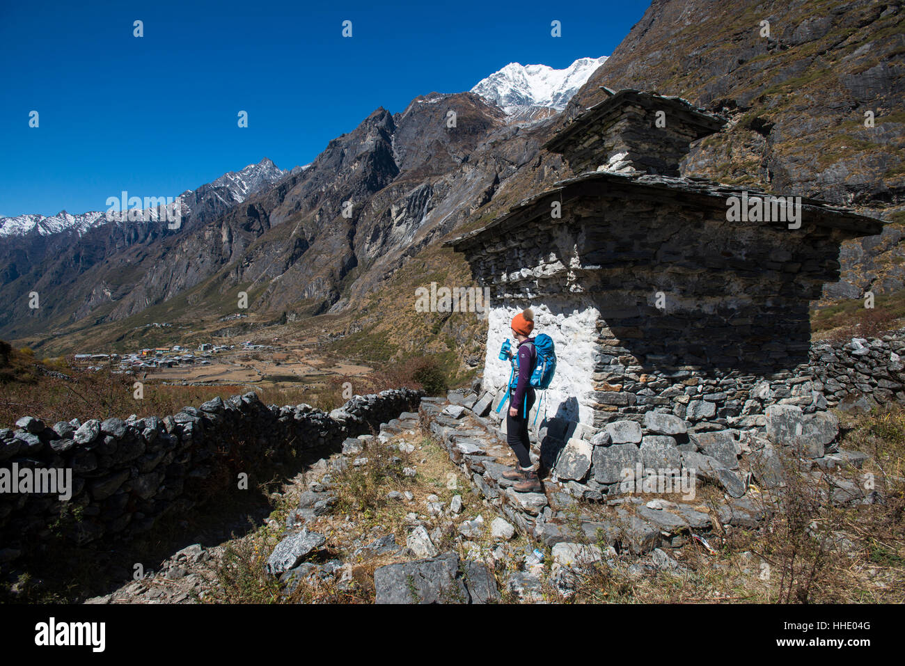 Une femme de la randonnée dans la vallée de Langtang repose près d'un chorten, Langtang Région, Népal Banque D'Images