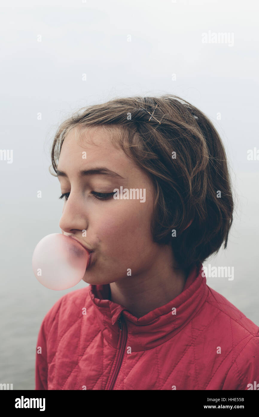 Onze ans girl blowing bubble gum bubble créer une grande compétence de la petite enfance bulle rose, bubblegum Banque D'Images