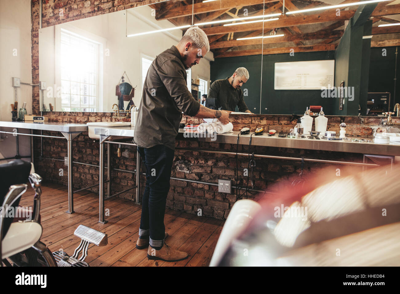 Photo de professionnel hommes coiffure au salon de coiffure. Coiffure hippie debout dans son magasin de préparer ses outils de travail. Banque D'Images
