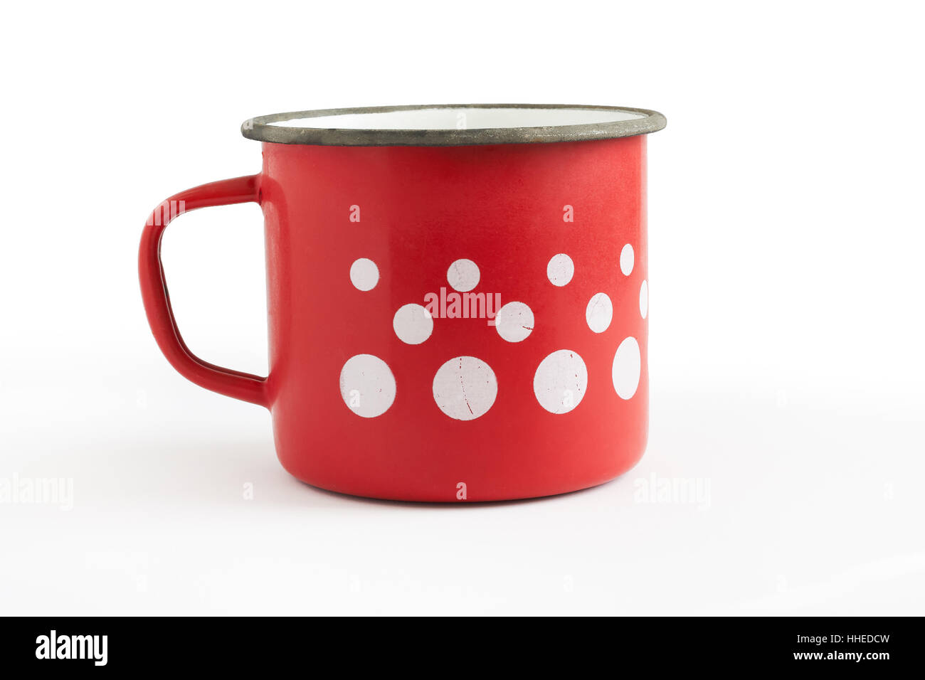 Ancienne tasse émail rouge à pois blancs isolé sur fond blanc Banque D'Images