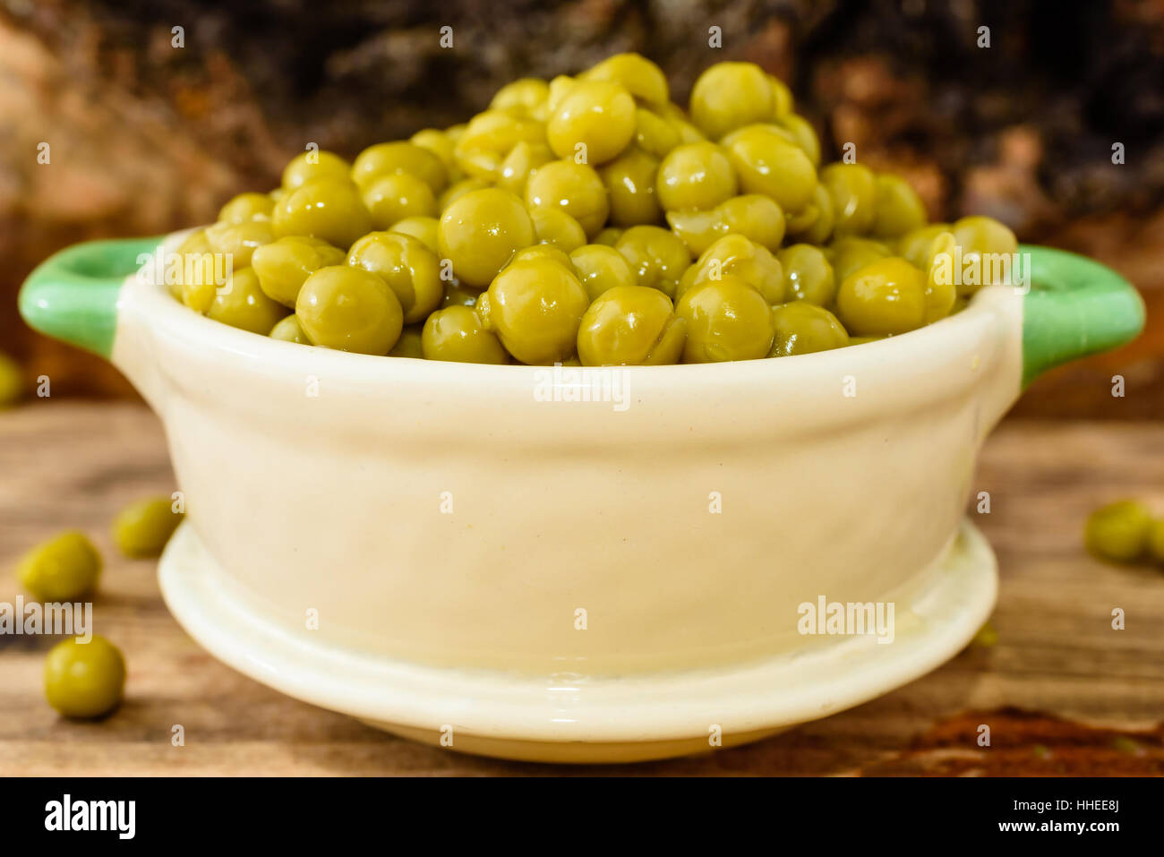 Etuve réfrigérée et les pois verts prêt à manger. Frais et doux au goût. Ici dans un beige et vert petit pot en fonte émaillée. Banque D'Images