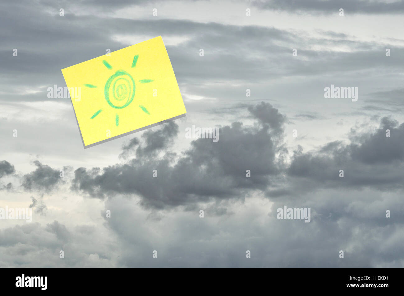 Ciel gris et nuageux sur un jour de pluie avec un post-it jaune avec un soleil dessiné à la main collé sur elle Banque D'Images
