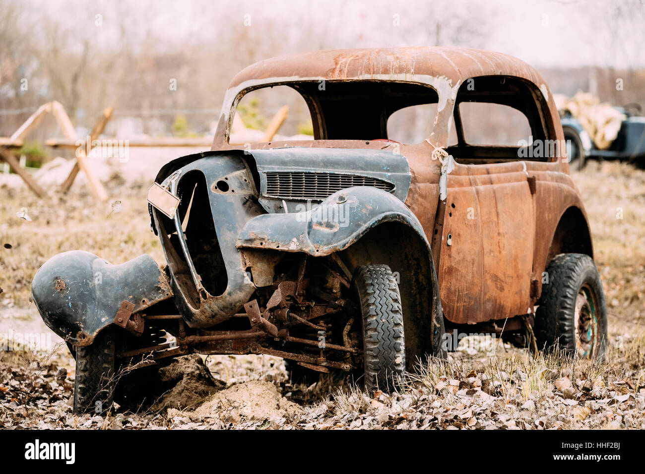 Vieille voiture rouillée s'est écrasé cassé abandonné pendant la Seconde Guerre mondiale est dans un champ d'automne. Banque D'Images