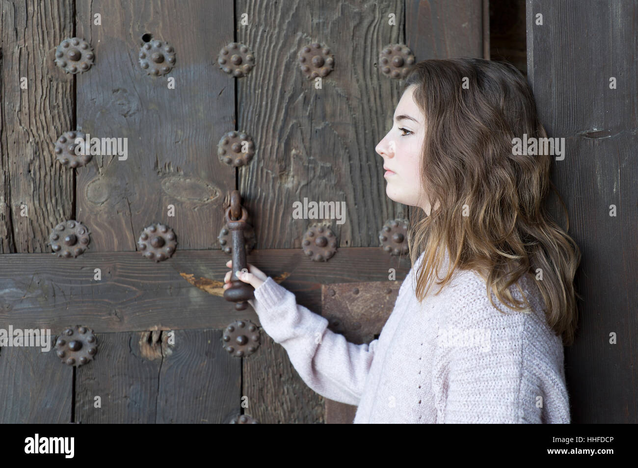 Fille de profil sur un fond d'une vieille porte. Plan horizontal avec lumière naturelle. Banque D'Images