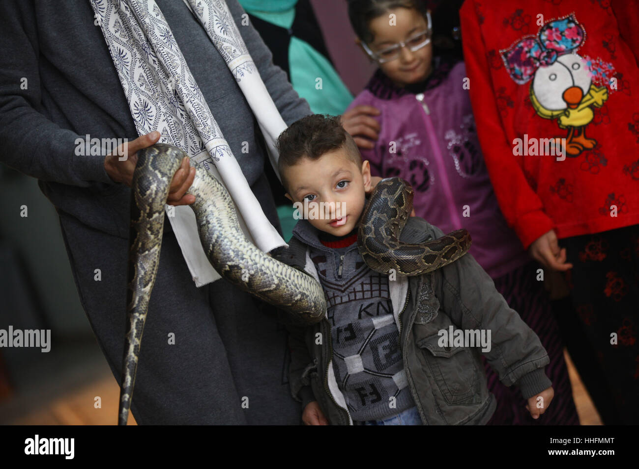 Giza, Egypte. 19 Jan, 2017. Un garçon pose pour une photo avec un python sur son épaule à Tolba's zoo privé à Gizeh, Egypte. Africano Tolba Village est un zoo privé établi par 50-year-old hunter Salah Tolba. Il a décidé de transformer son hobby en une exposition d'animaux rares d'affaires par l'intermédiaire d'un zoo privé sous licence. Source : Xinhua/Alamy Live News Banque D'Images