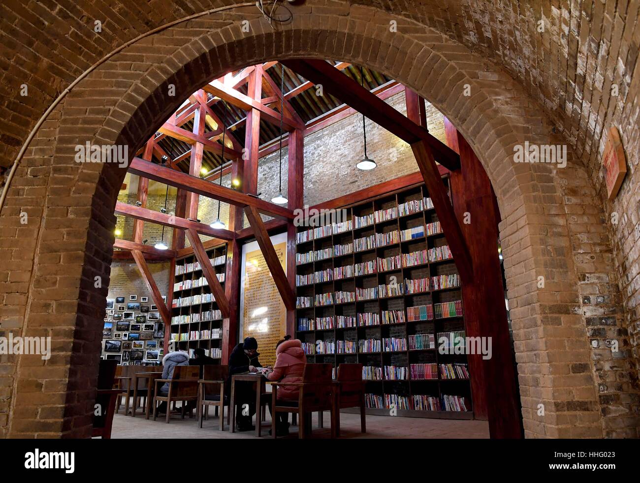 (170119) -- MENGZHOU, Janvier 19, 2017 (Xinhua) -- Les touristes lire des livres à un habitat troglodytique dans bibliothèque Mogou Village de Mengzhou Ville, Centre de la Chine, la province du Henan, le 19 janvier 2017. L'habitat troglodytique bibliothèque, couvrant une superficie d'environ 4 000 mètres carrés, comprend plus de 50 000 volumes. Il est ouvert au public gratuitement. (Xinhua/Li Un)(mcg) Banque D'Images