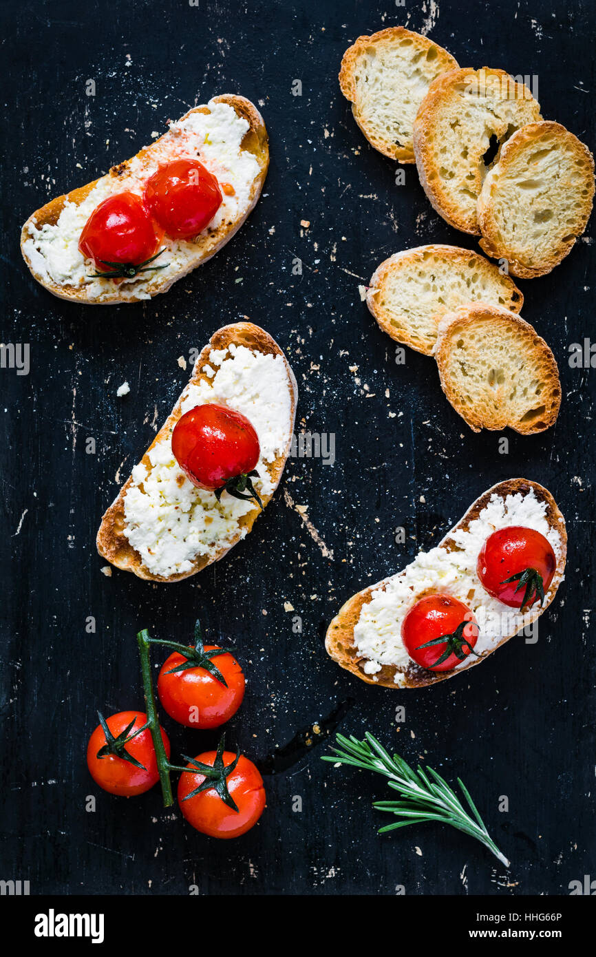 Crostini Toast bruschetta à la ricotta fromage blanc frais, tomates cerises rôties à l'ail et l'huile d'olive. Vue d'en haut Banque D'Images