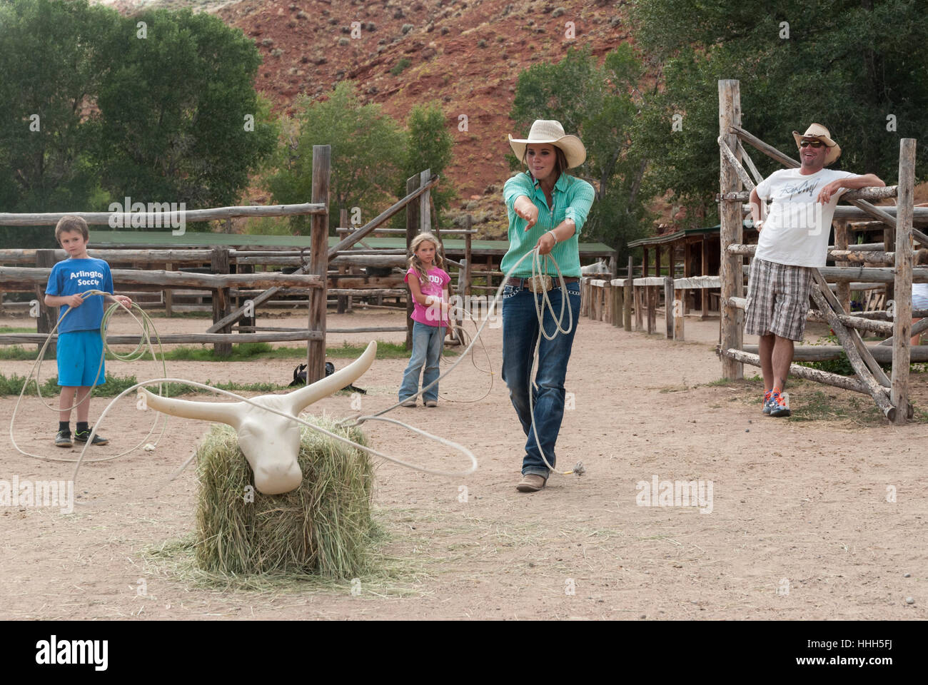 Bouts de pratiquer à l'Lazy L&B dude ranch en Dubois, Wyoming : Wrangler lassos une balle de foin vache tandis que les enfants attendent leur tour. Banque D'Images