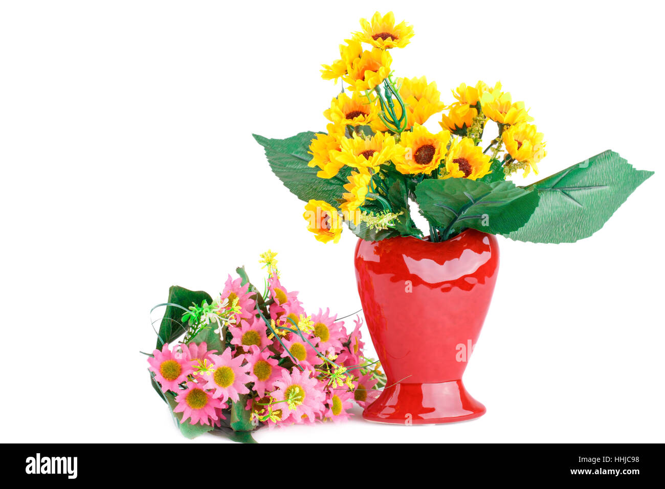 Tissu jaune fleurs dans vase et fleurs rose isolé sur fond blanc. Banque D'Images