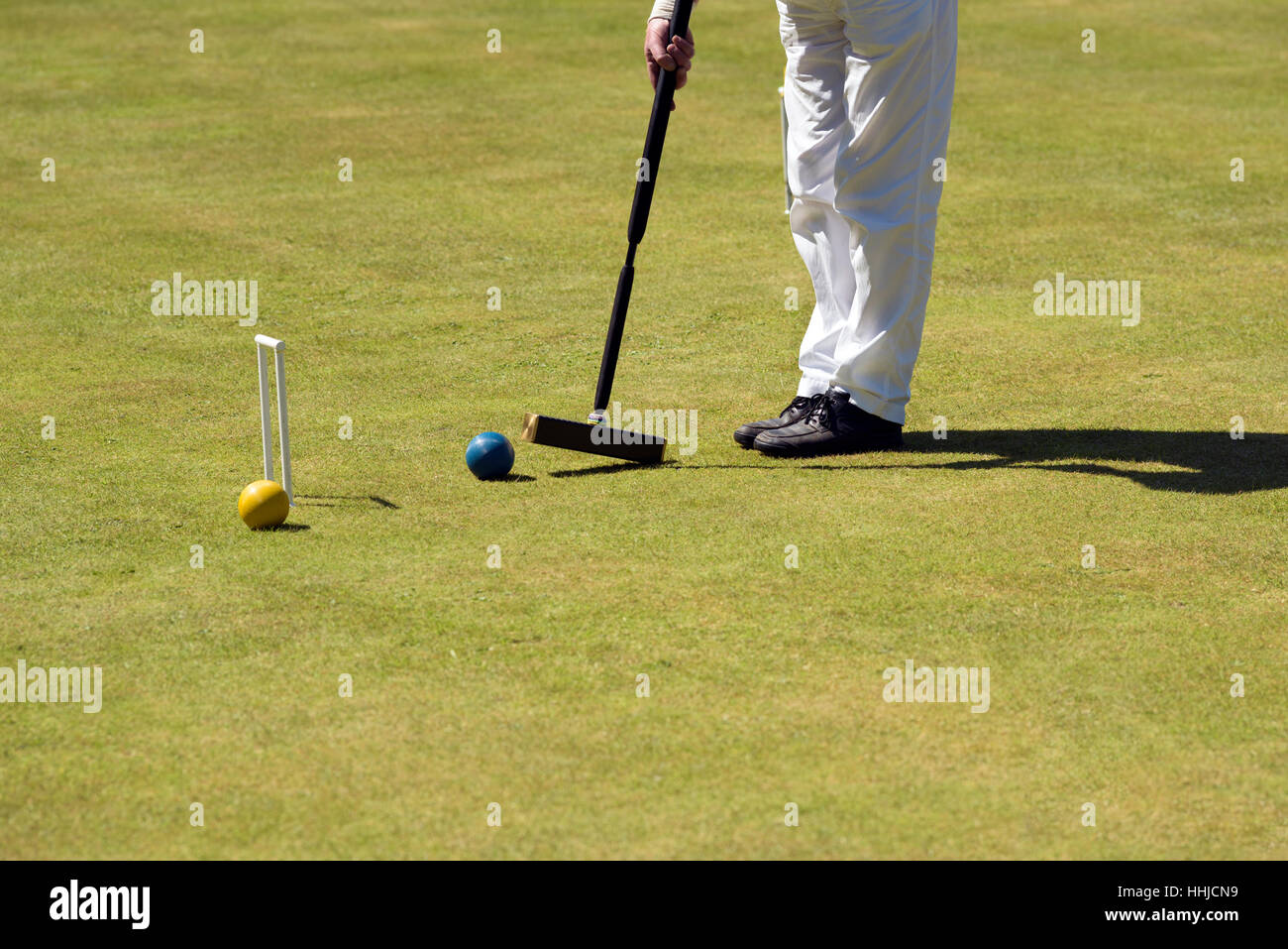 Portrait d'un homme frapper une balle avec un maillet de croquet. Banque D'Images