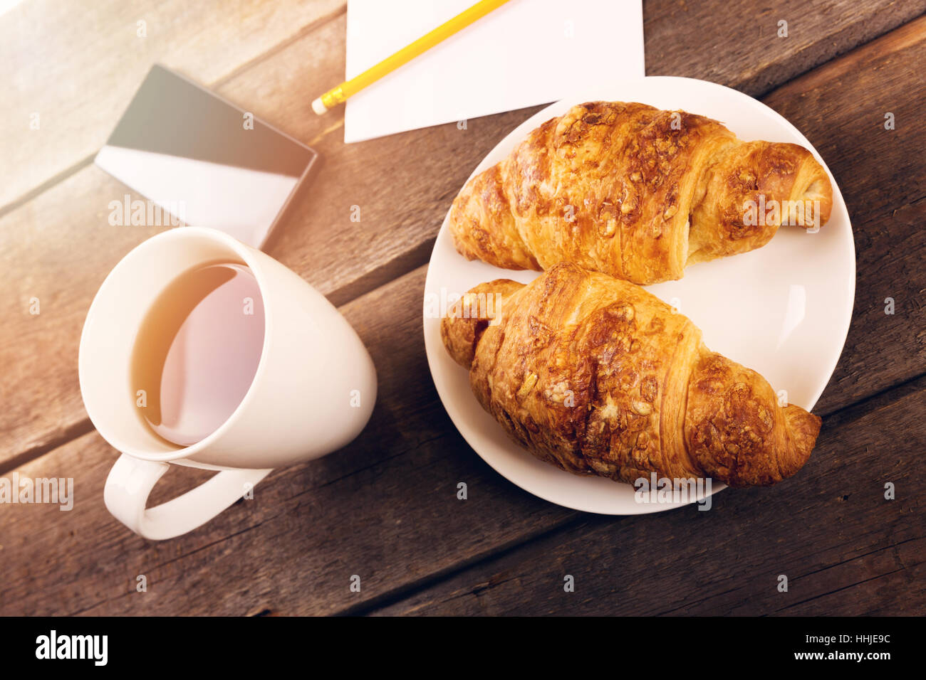 Petit-déjeuner croissant et tasse de thé sur la vieille table en bois Banque D'Images