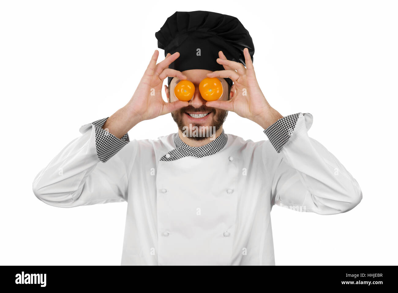 Happy chef couvrant ses yeux avec des tomates isolated on white Banque D'Images